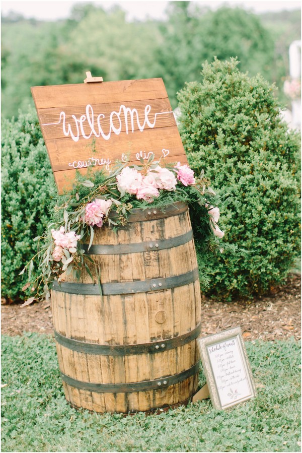 pink flowers on rustic wine barrel outdoor welcome sign decortaion ideas