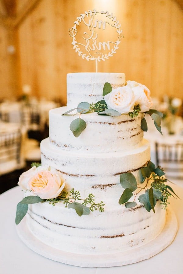 rustic naked wedding cake decorated with eucalyptus greenery and a mix of peach Juliet and white and blush garden roses