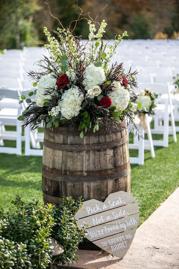 wedding ceremony barrels with red roses and white hydrangeas on top