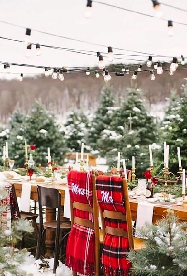 winter wedding decorations a wedding table on the street decorated with white candles of golden candlesticks and chairmasters with a red checkered scarf