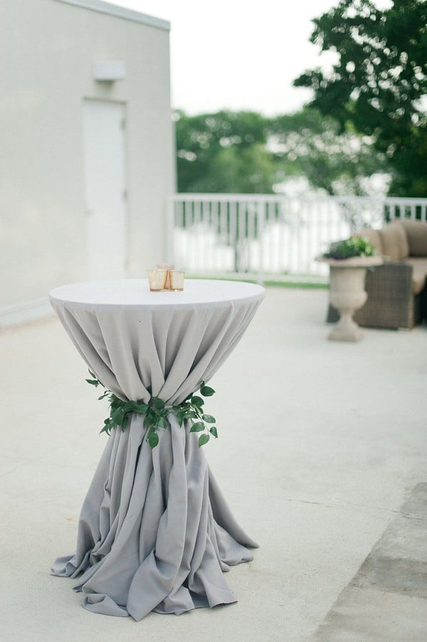 Neutral grey wedding cocktail table with greenery