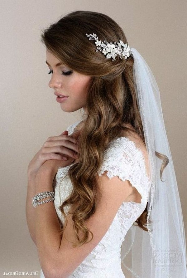 Romantic half up half down hairstyle with soft waves and tule veil