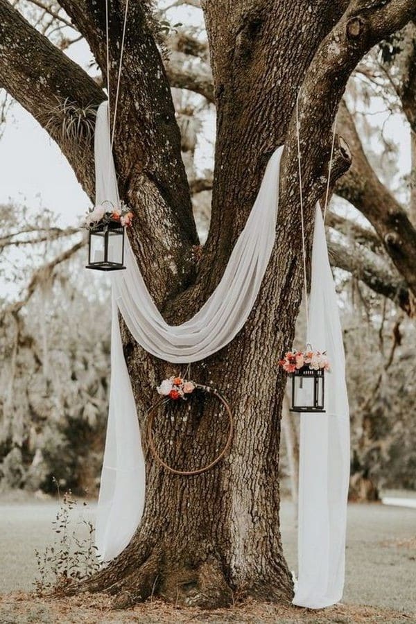 boho chic wedding backdrop ideas with white drapery and lanterns