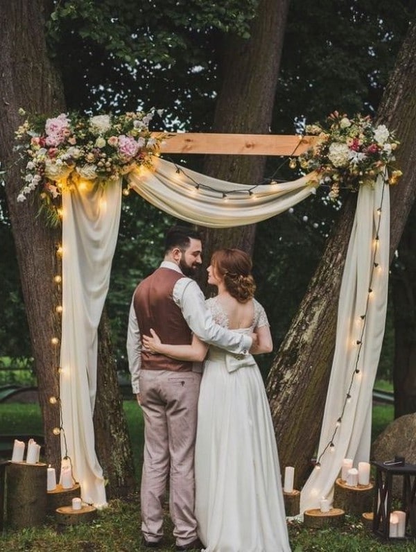 draped fabric and lights wedding arch