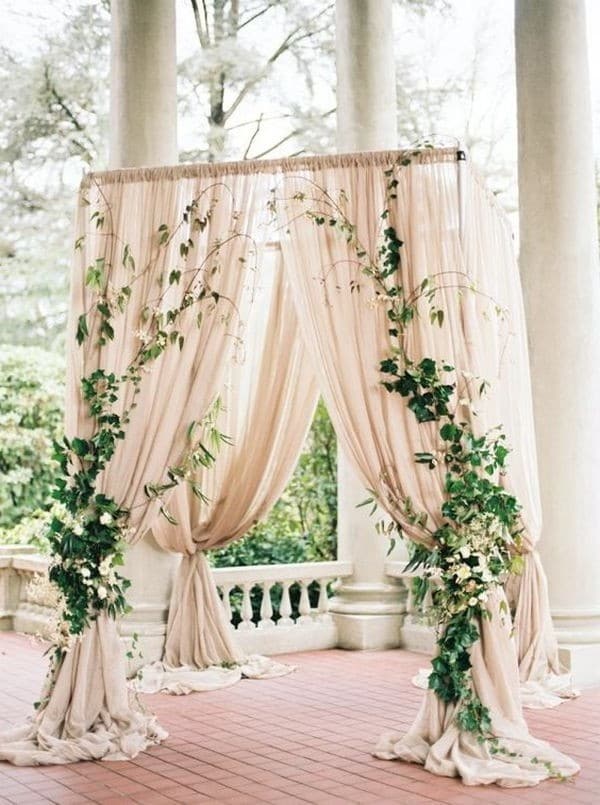 elegant outdoor wedding arch ideas with neutral drapery and greenery