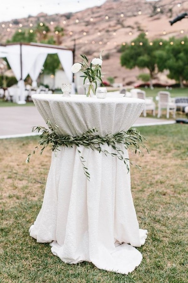 elegant wedding cocktail table decorated with olive leaves