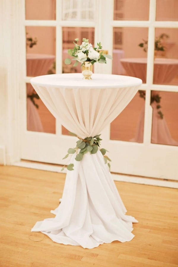 ivory wedding cocktail table with greenery